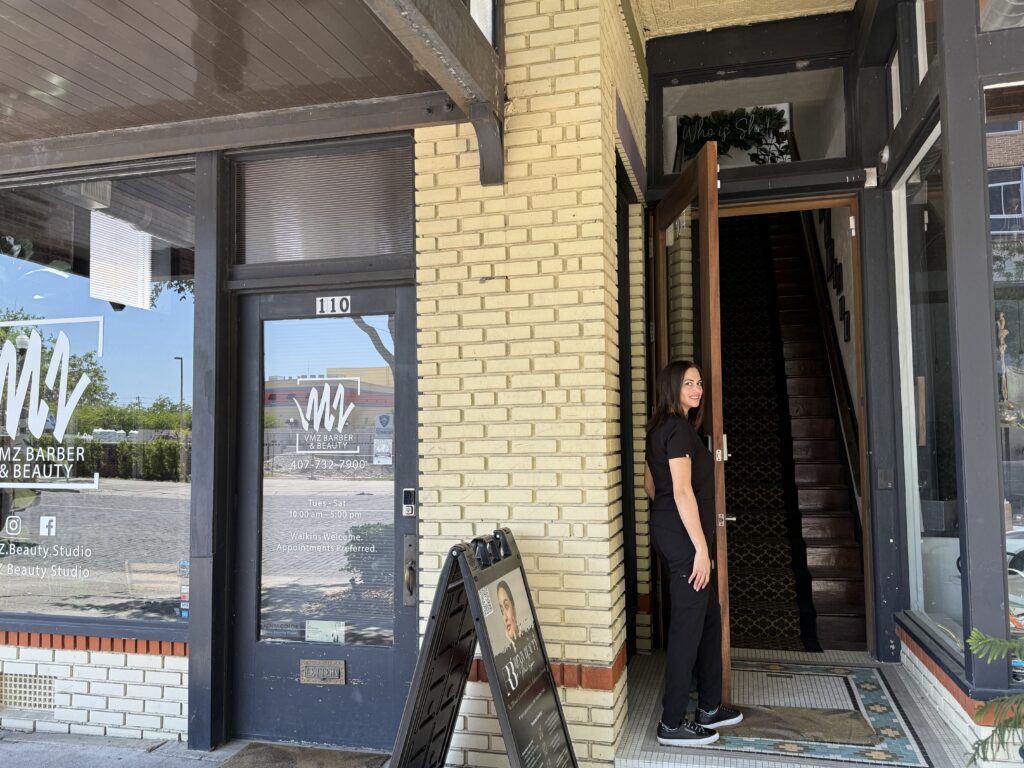 Kristen-Anne Thomas, FNP-BC, standing at the entrance to Reviv Beauty Med Spa, located upstairs at 104 S Park Ave, Sanford, FL