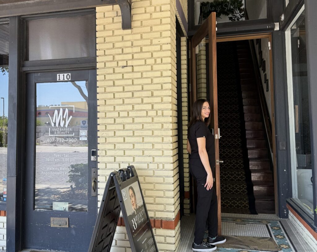 Kristen-Anne Thomas, FNP-BC, standing at the entrance to Reviv Beauty Med Spa, located upstairs at 104 S Park Ave, Sanford, FL