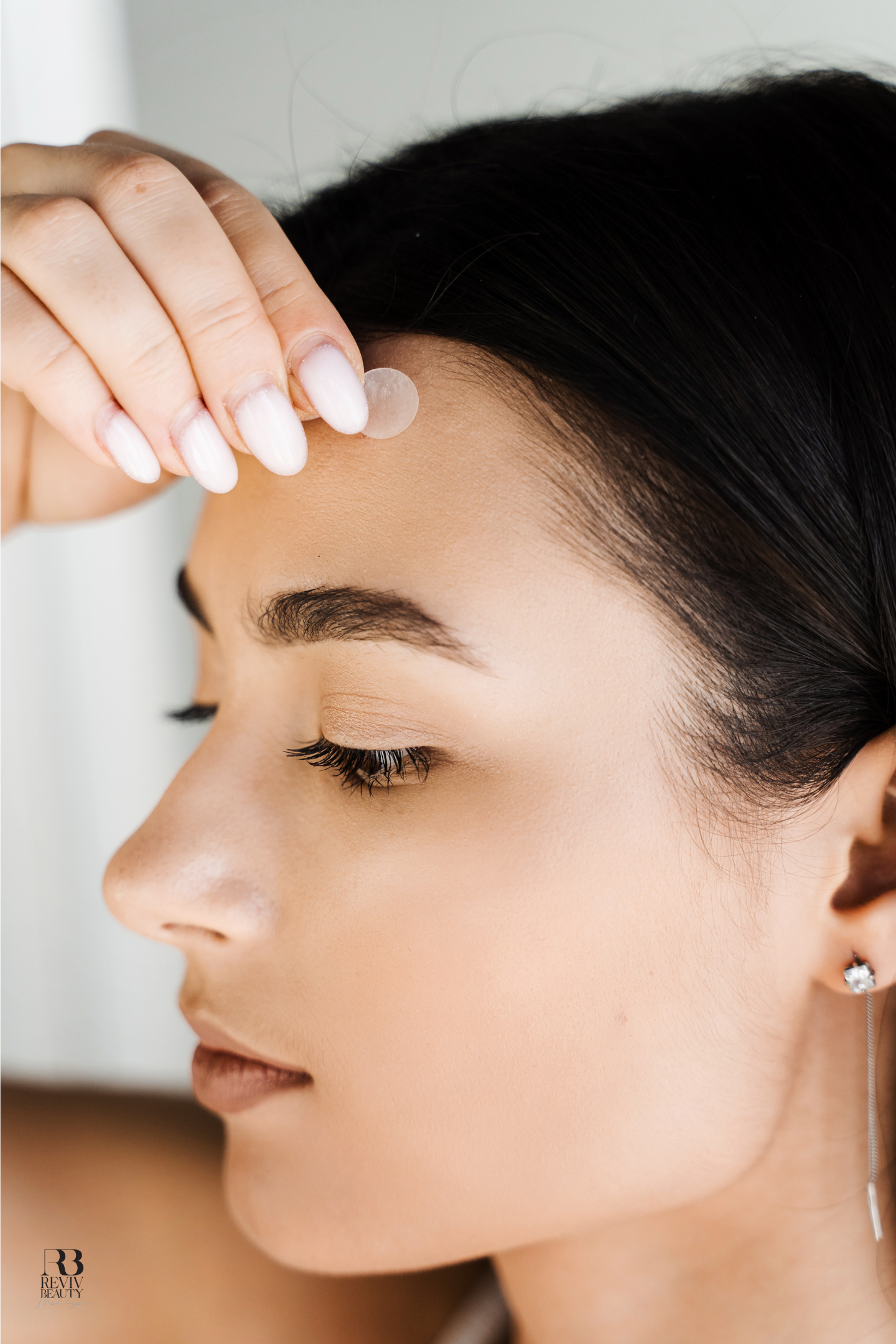 Close-up of a woman touching her forehead, representing acne-prone skin support and skin booster treatments at Reviv Beauty Med Spa in Sanford, FL.